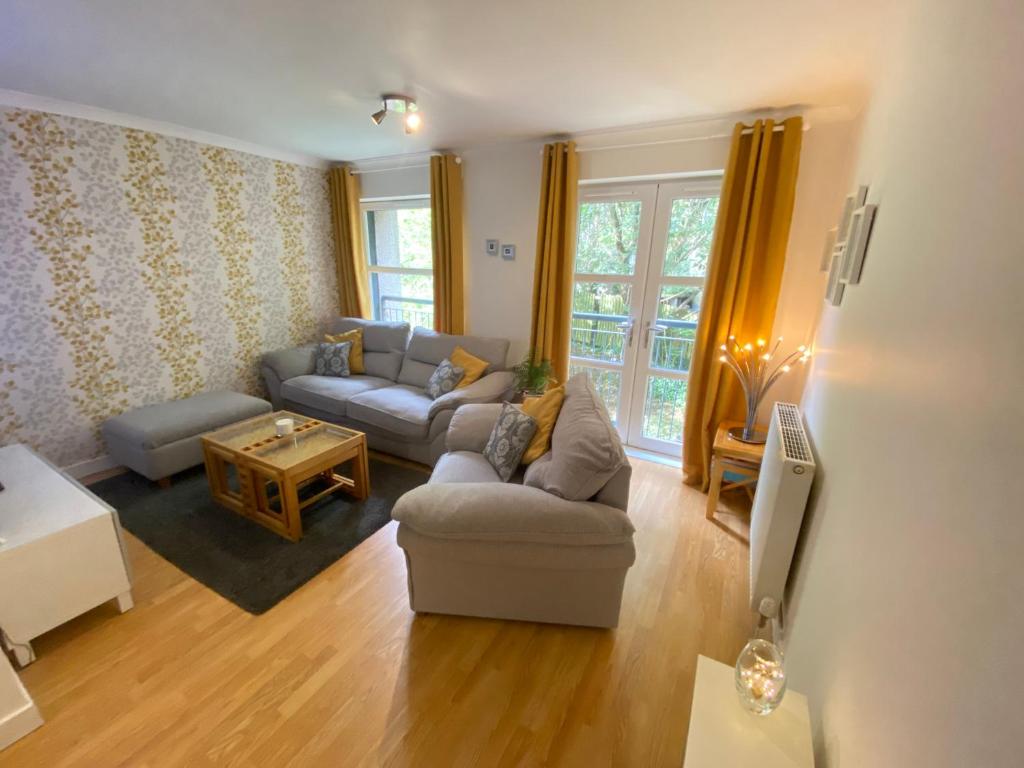 a living room with a couch and a table at Paisley Central Apartment in Paisley