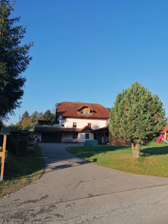 a house with a tree on the side of a road at Ferienwohnung Familie Pichler in Neumarkt in Steiermark