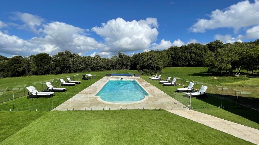 - une vue sur la piscine et ses chaises longues dans l'établissement GiteDordogne, à Jumilhac-le-Grand