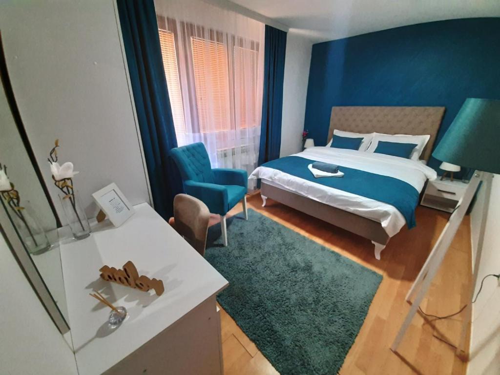 フォチャにあるApartman Laraの青い壁のベッドルーム1室(ベッド1台付)