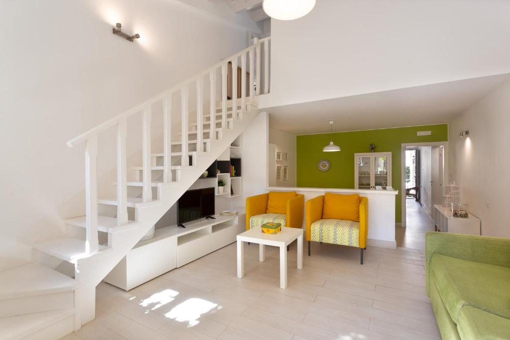 een woonkamer met een trap en een gele bank bij "Le Casette di Ninetta" - Casa vacanza Casmene in Donnalucata