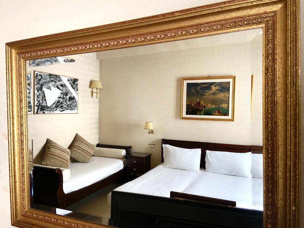 a mirror in a hotel room with two beds at Ca' Del Nobile in Venice