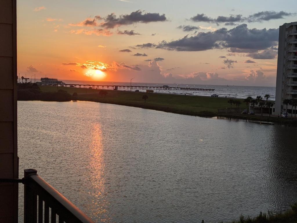 a sunset over a body of water next to a beach at Gulf View, Flip Flop Oasis GVR06432 in Galveston