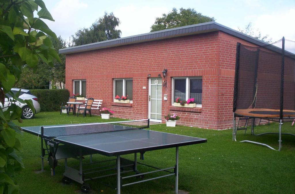 a ping pong table in front of a brick building at Ferienhaus-Bender-Rügen in Maltzien