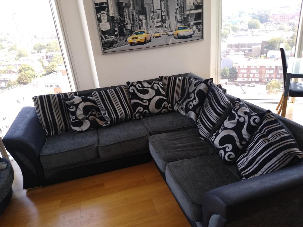 a black couch with pillows on it in a living room at Room in Luxurious Penthouse Apartment in London