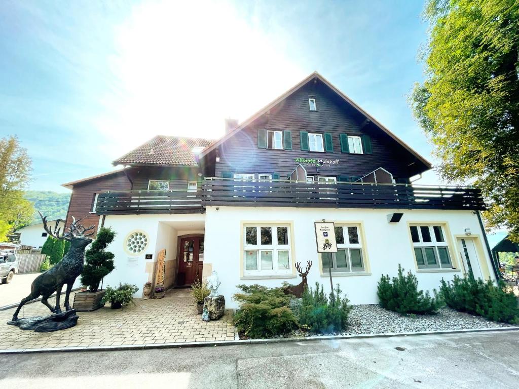 a house with a statue in front of it at Albhotel Malakoff - House of Nature in Wiesensteig