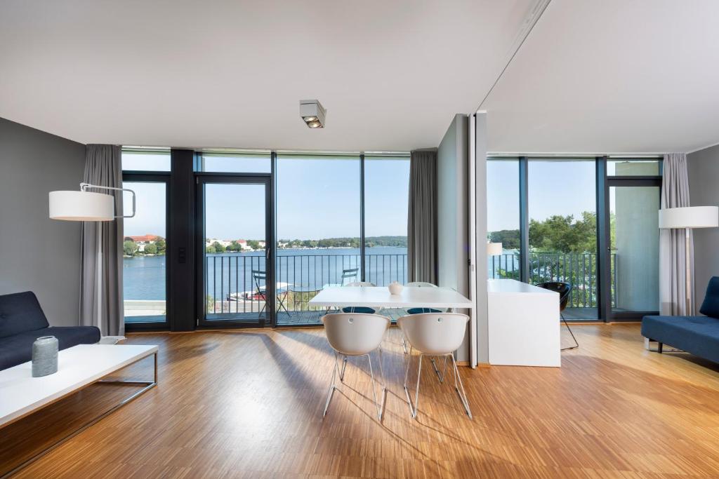ein Wohnzimmer mit einem Tisch und Stühlen mit Aussicht in der Unterkunft Waveboard Hotel & Boardinghouse in Potsdam