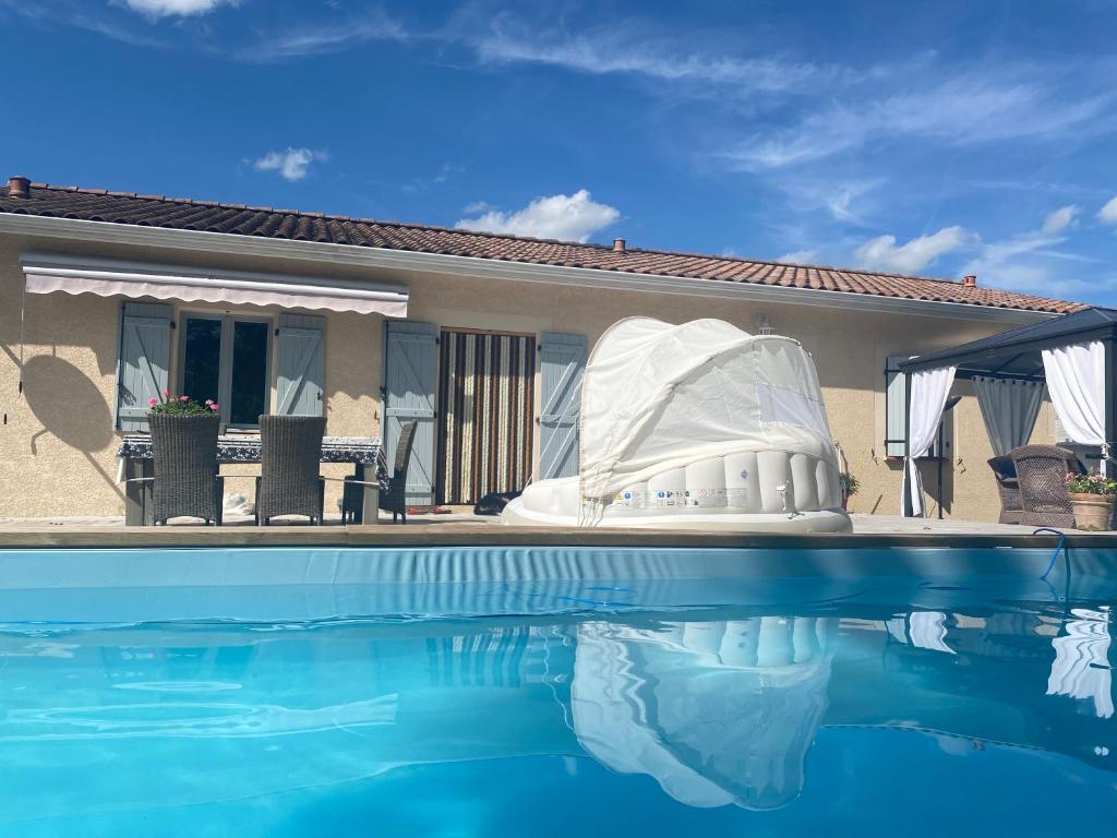 a white boat sitting next to a swimming pool at Maison des Vignes in Caylus