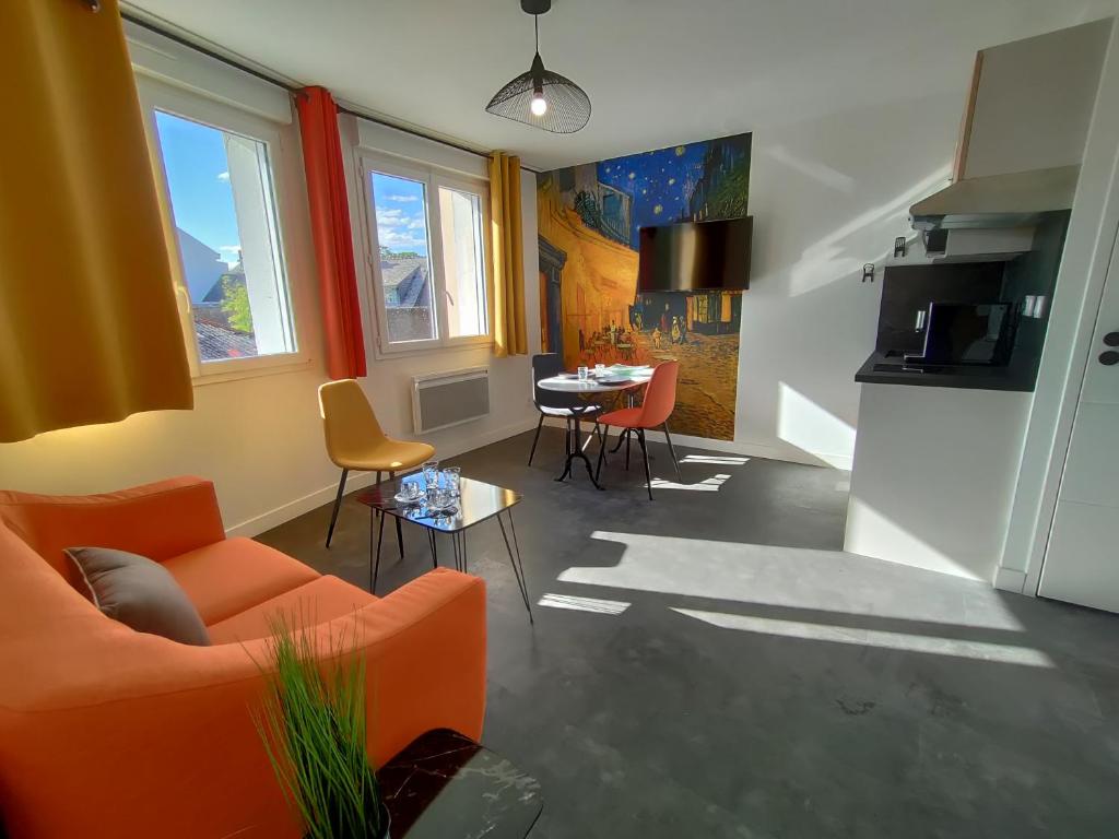 - un salon avec un canapé orange et une table dans l'établissement Résidence M - LAVALOC, à Laval