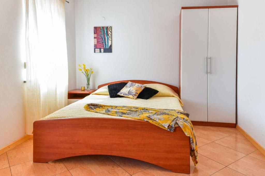 sypialnia z łóżkiem z drewnianym zagłówkiem w obiekcie Apartments in Stara Baska - Insel Krk 34433 w mieście Stara Baška