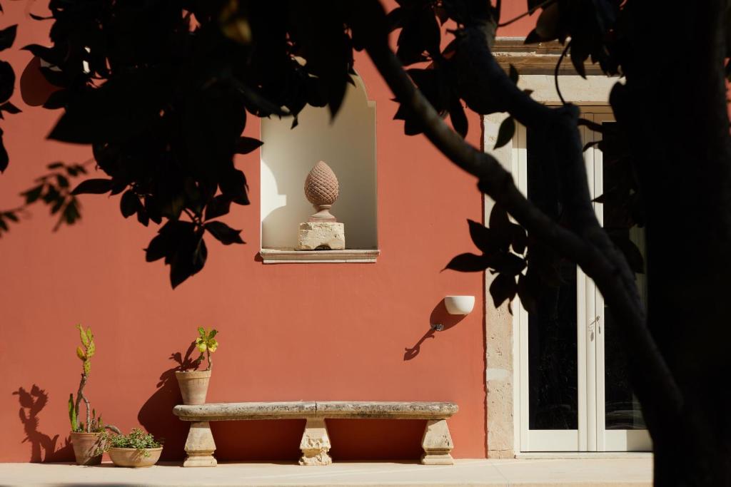 a wall with a bench in front of a building at Petra - Country House in Monteroni di Lecce