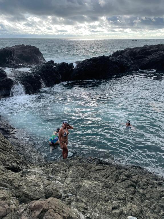 a group of people in the water at the beach at Alojamiento in Bahía Solano