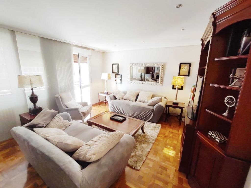a living room with two couches and a table at Apartamento turístico San Juan in Pamplona