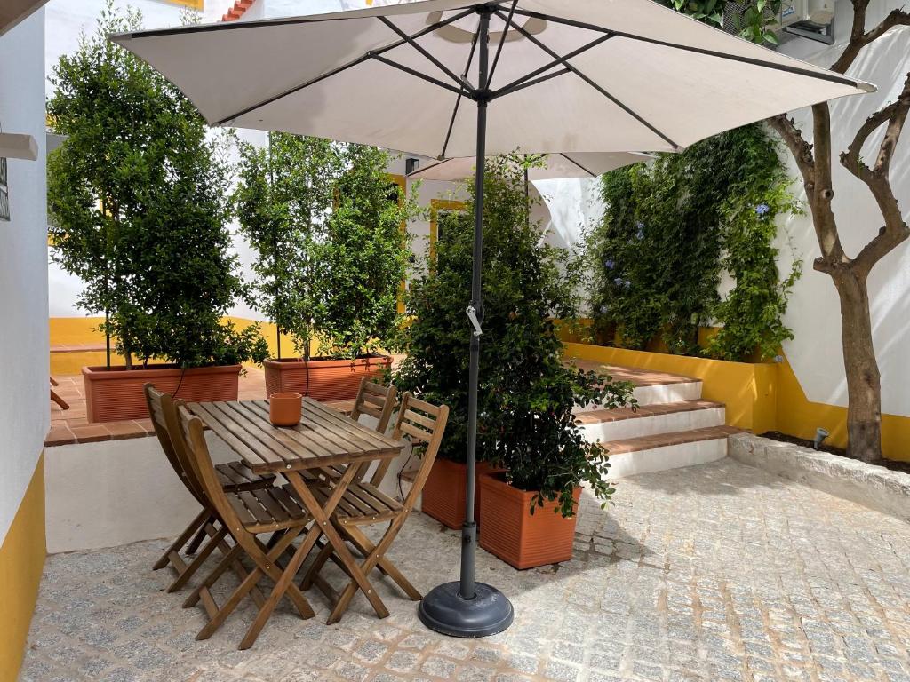 a table and chairs with an umbrella on a patio at Casa Carmo in Évora
