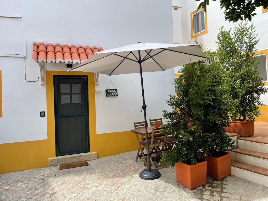 a table with an umbrella in front of a building at Casa Carmo in Évora