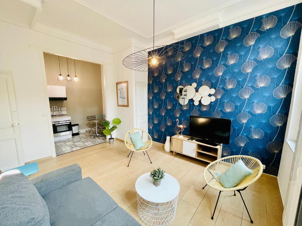 una sala de estar con una pared azul con conchas en Marseille 6ème Vauban élégant T3 6 couchages 2 chambres, en Marsella