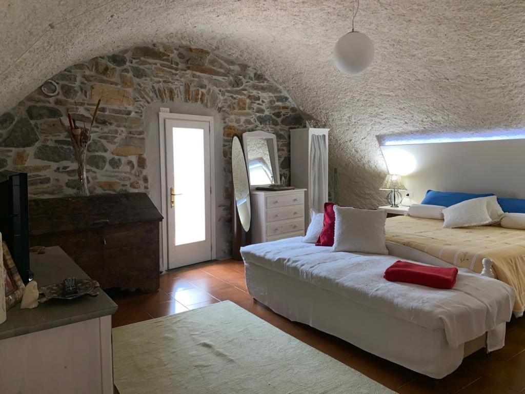 CimbergoにあるAppartamento immerso nel cuore del parco dell Adamelloの石壁のベッドルーム1室(ベッド2台付)