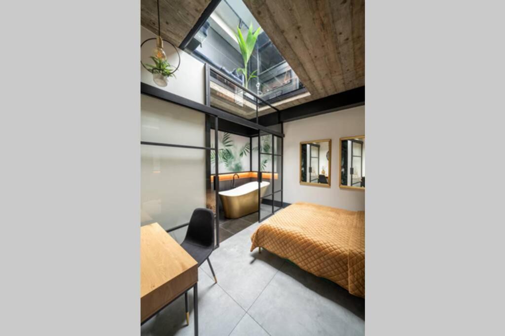 een slaapkamer met een bed en een bureau in een kamer bij No 7 Apartament Spa z sauna i jacuzzi in Nowy Targ
