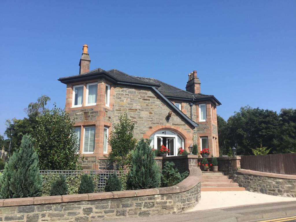 a large brick house with two chimneys at Carnaby Lodge in Dingwall