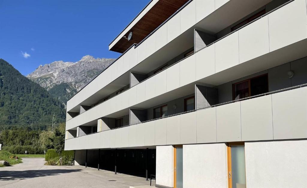 a white building with mountains in the background at Ferienwohnung Herold in Bartholomäberg