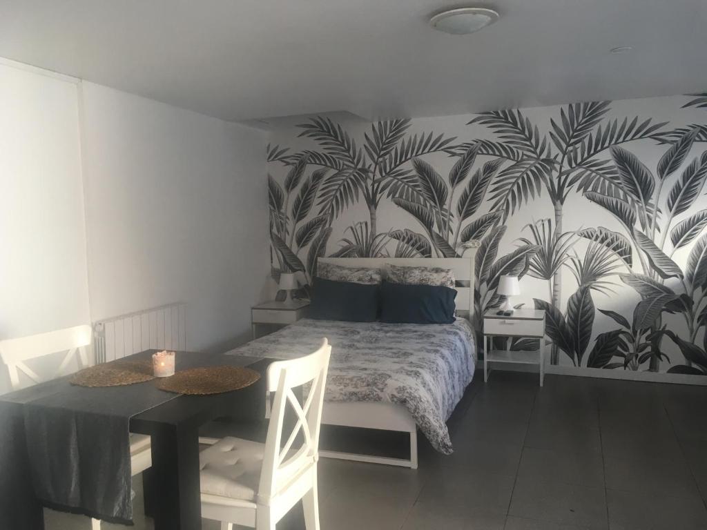 une chambre avec un lit, une table et un mur dans l'établissement Lolita place, à Obernai
