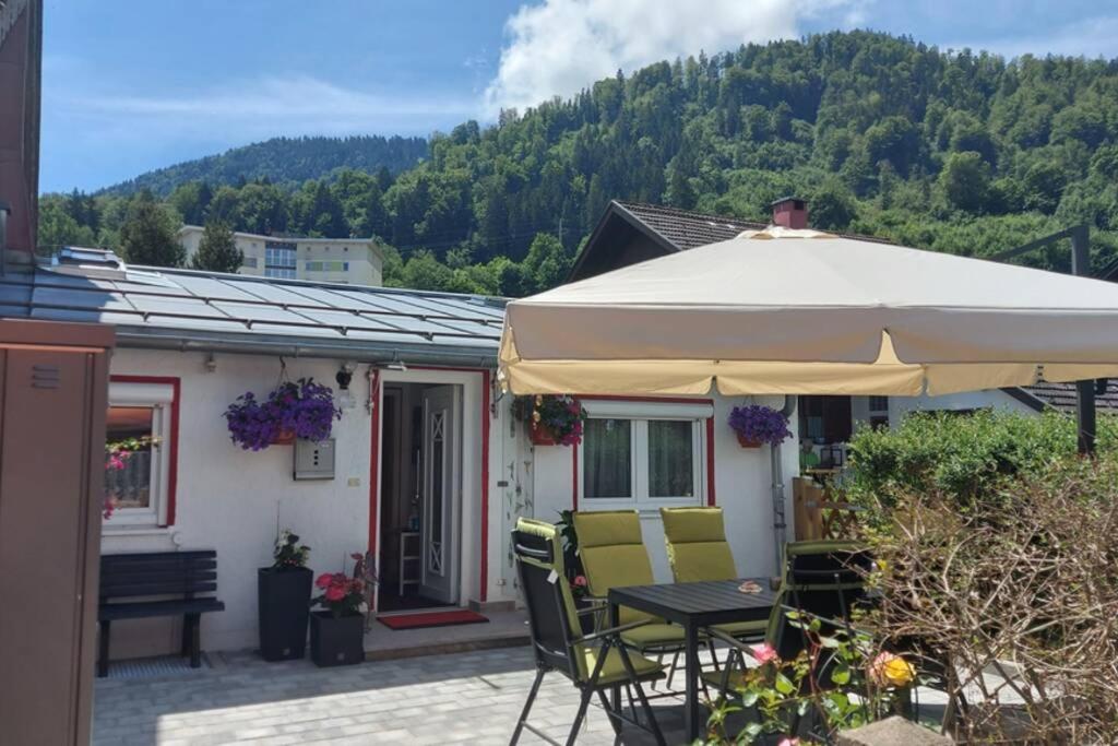 eine Terrasse mit einem Tisch und Stühlen unter einem Sonnenschirm in der Unterkunft Ferienhaus Gabriela Allgäu in Immenstadt im Allgäu
