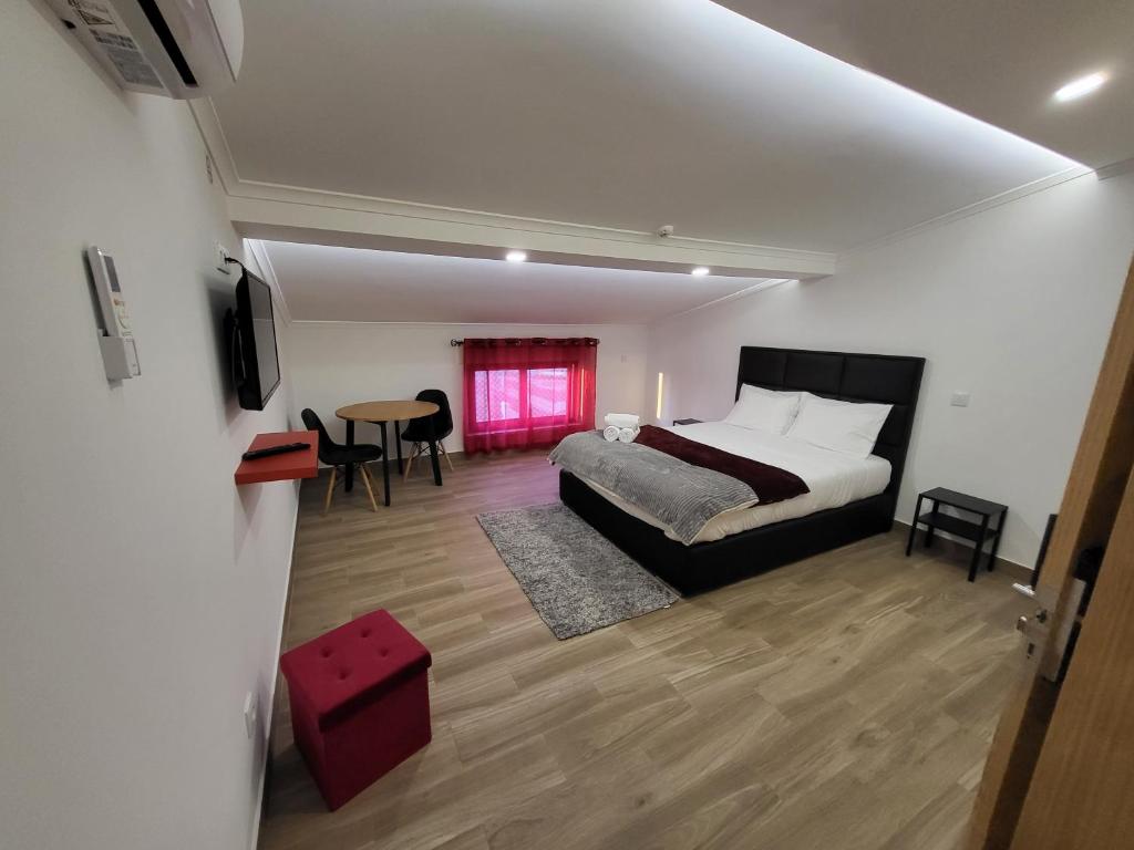 a bedroom with a bed and a table with chairs at Casa Borges in Charneca