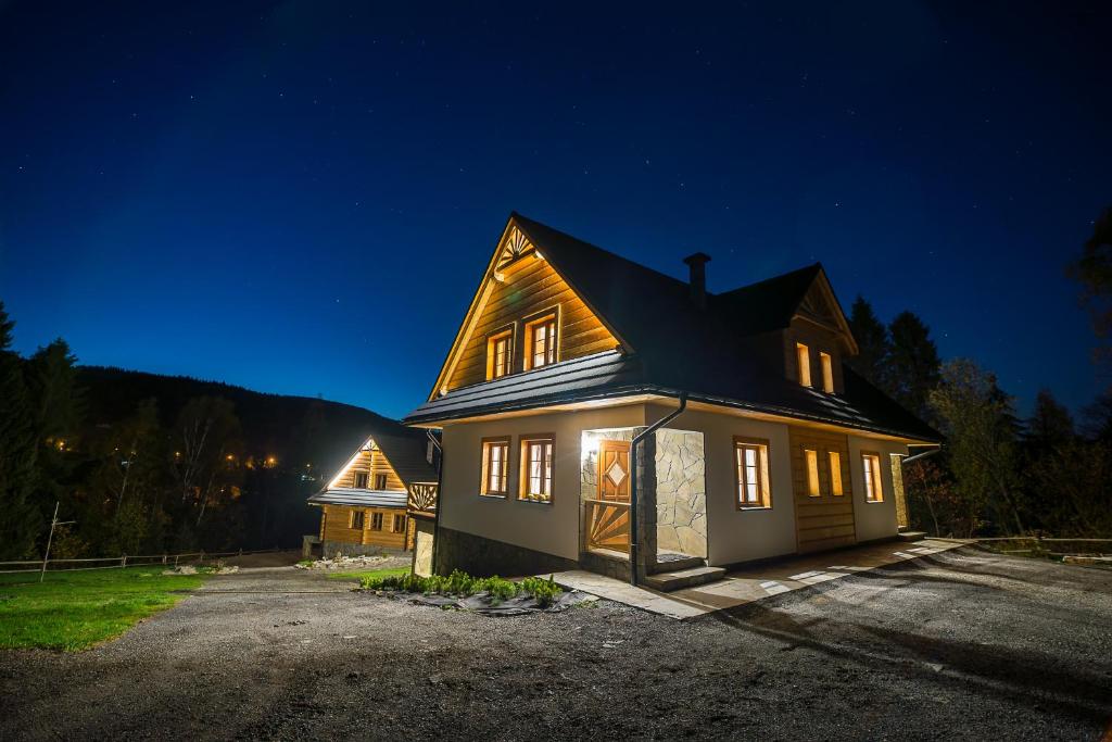 ein großes Haus in der Nacht mit eingeschaltetem Licht in der Unterkunft Chata Smagula in Korbielów