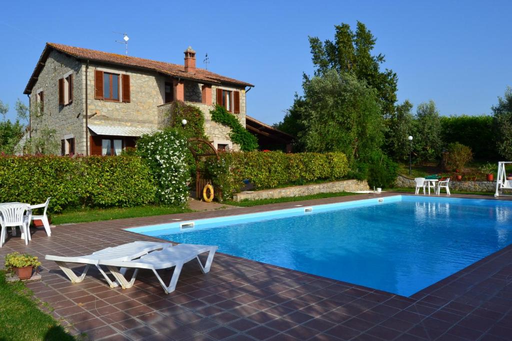 a house with a swimming pool in front of a house at Le Macchie in Baschi