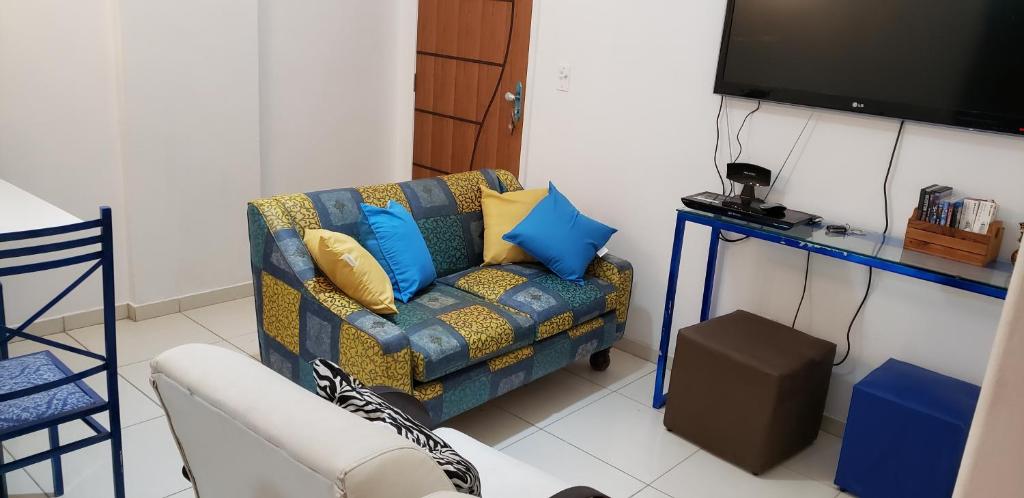 a living room with a couch and a tv at Apto Jacaraipe - quadra praia - excelente in Jacaraípe