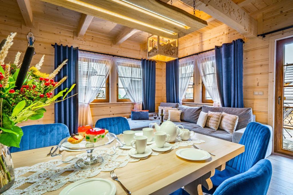 une salle à manger avec une table et des chaises bleues dans l'établissement Smrekowy Domek, à Kościelisko