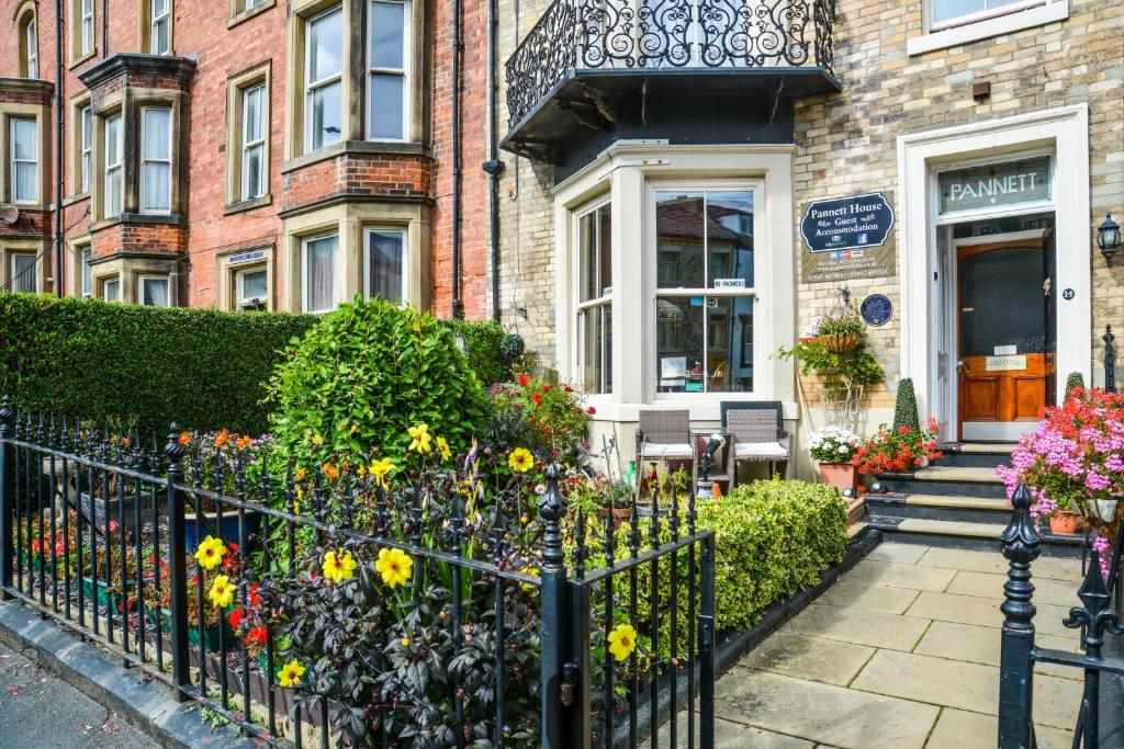 a house with a fence with flowers in front of it at Pannett House Guesthouse in Whitby