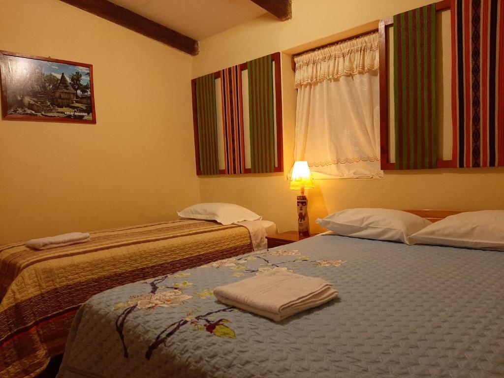 Habitación con 2 camas, lámpara y ventana en Healthy Stay Gocta, en Cocachimba