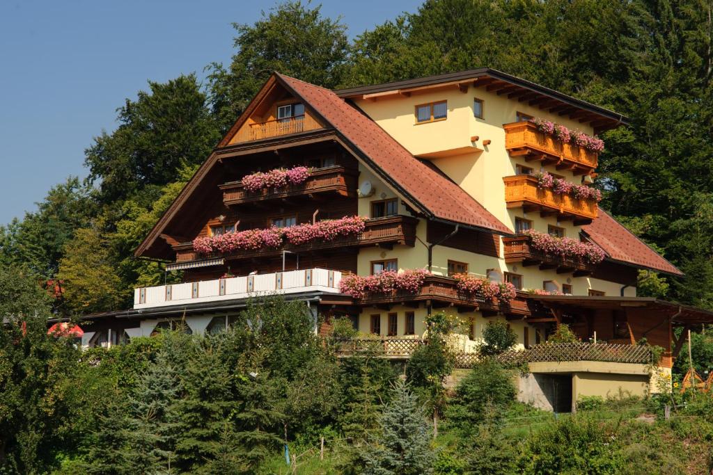 a large house with flowers on the side of it at Gasthof Thomann in Velden am Wörthersee