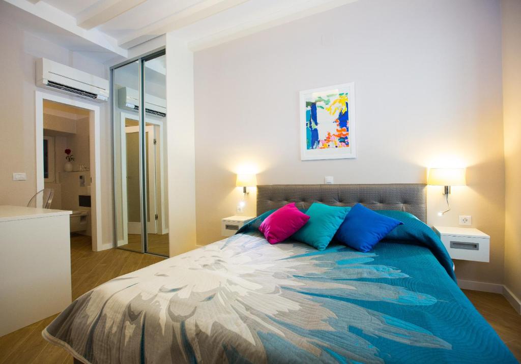 Villa Flores Room في دوبروفنيك: غرفة نوم مع سرير ووسائد زرقاء وردية