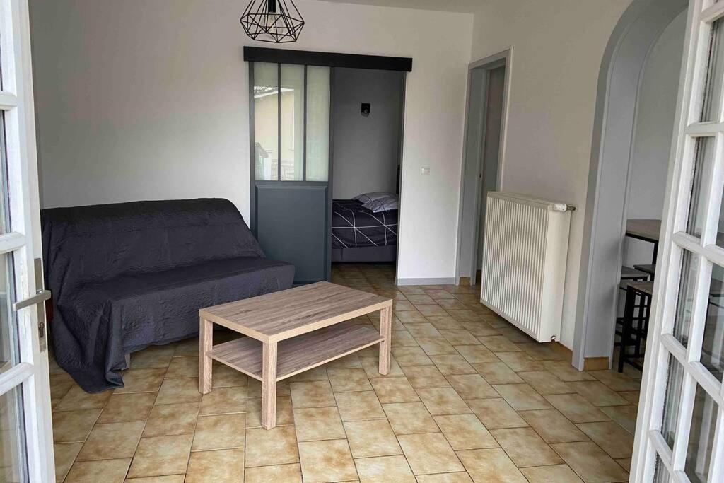 een woonkamer met een bank en een salontafel bij Appartement chaleureux au cœur d un village classé in Villebois-Lavalette