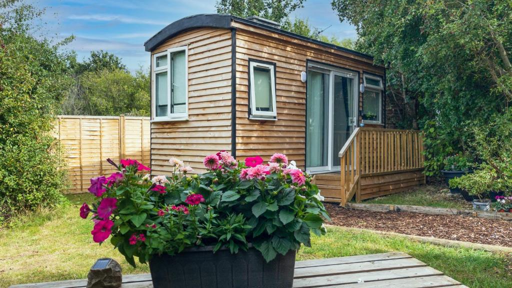 a tiny house with a flower pot in front of it at Shepherds hut Bath in Wick