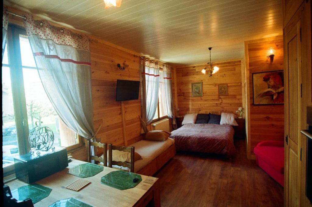 a bedroom with a bed and a table in a room at Chouette in Annecy