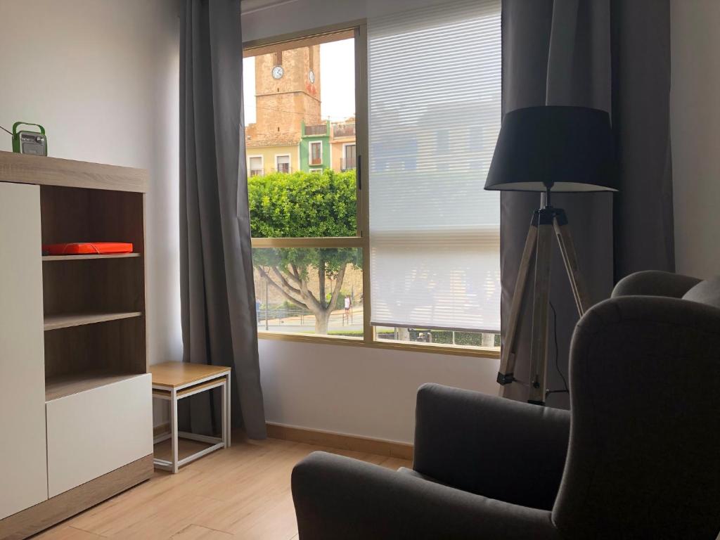 sala de estar con ventana con silla y lámpara en Apartamento Plaza, en Villajoyosa
