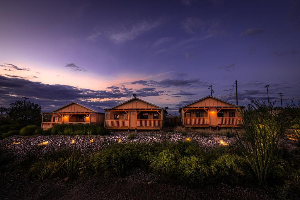 a row of wooden huts at night with lights at Tombstone Miners Cabins in Tombstone