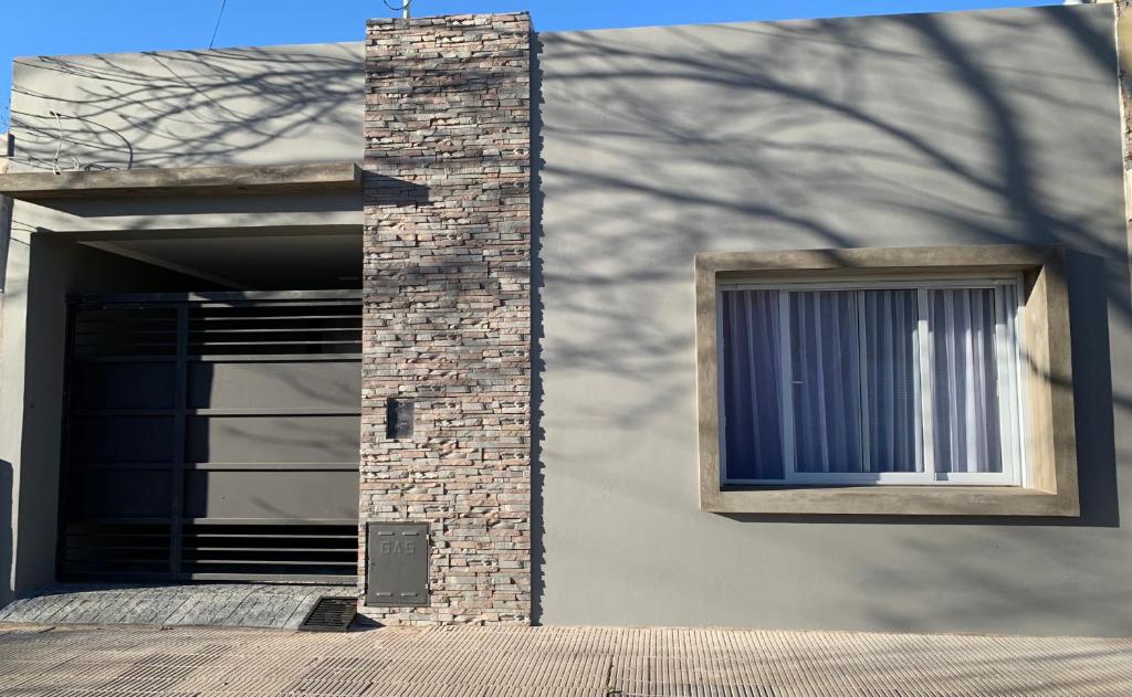 un edificio con un pilar de ladrillo y una ventana en La Casita, en Carhué
