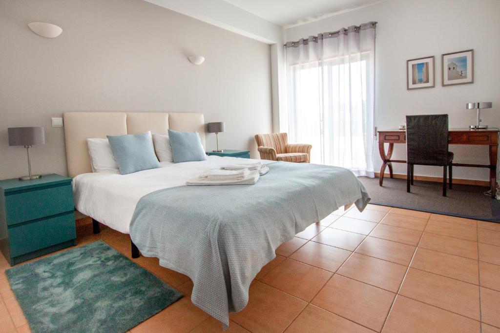 um quarto com uma cama grande e uma secretária em Nortada Suite Beach Apartment T2 em Lagos