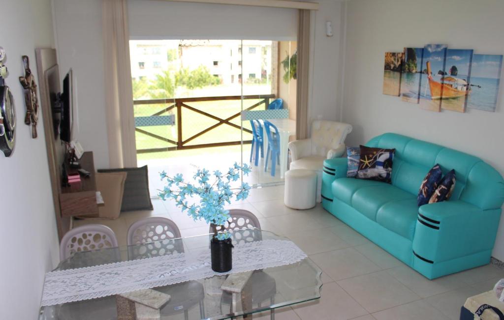 a living room with a blue couch and a table at Villa das Águas-reservas in Estância