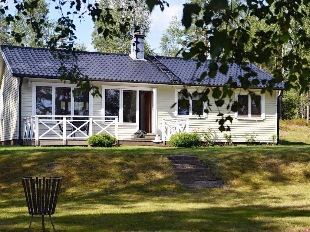 une maison blanche avec un toit en gambrel dans l'établissement 4 person holiday home in GISLAVED, à Gislaved