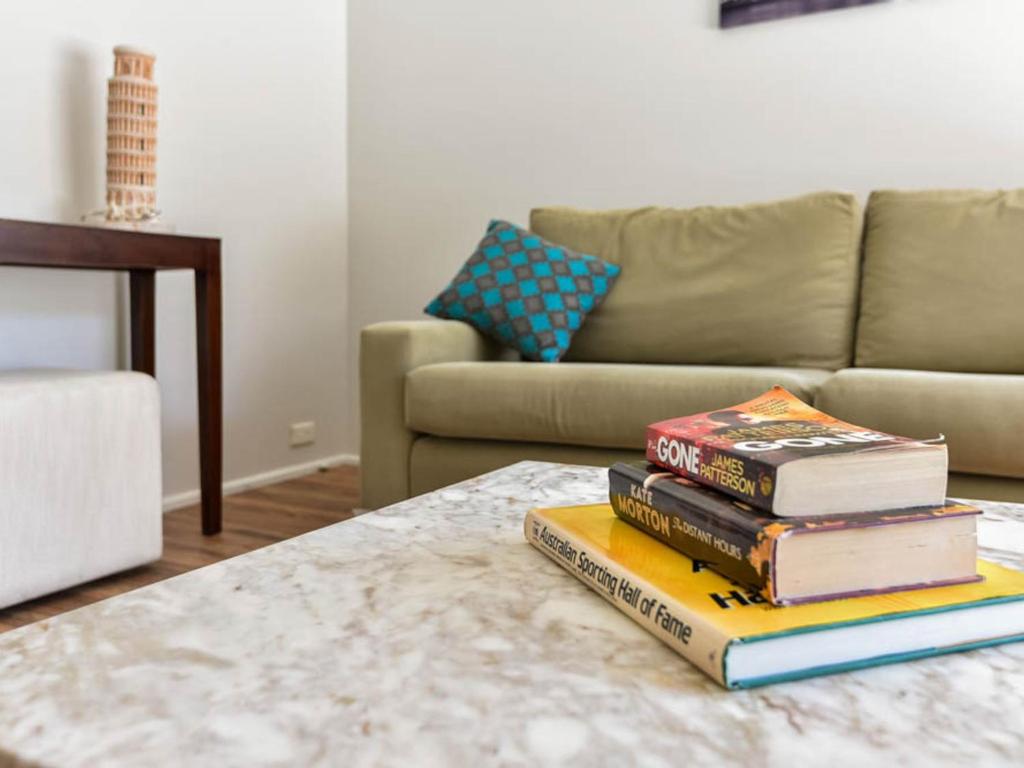 a pile of books sitting on a coffee table at Noraville Summer House in Norah