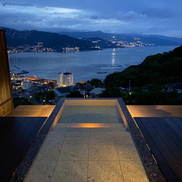 uma vista para a água à noite a partir de um edifício em Uminohana em Atami