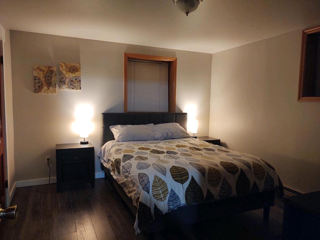 a bedroom with a bed with two night stands and two lamps at 5th and Beall 1 bedroom apartment close to downtown in Bozeman