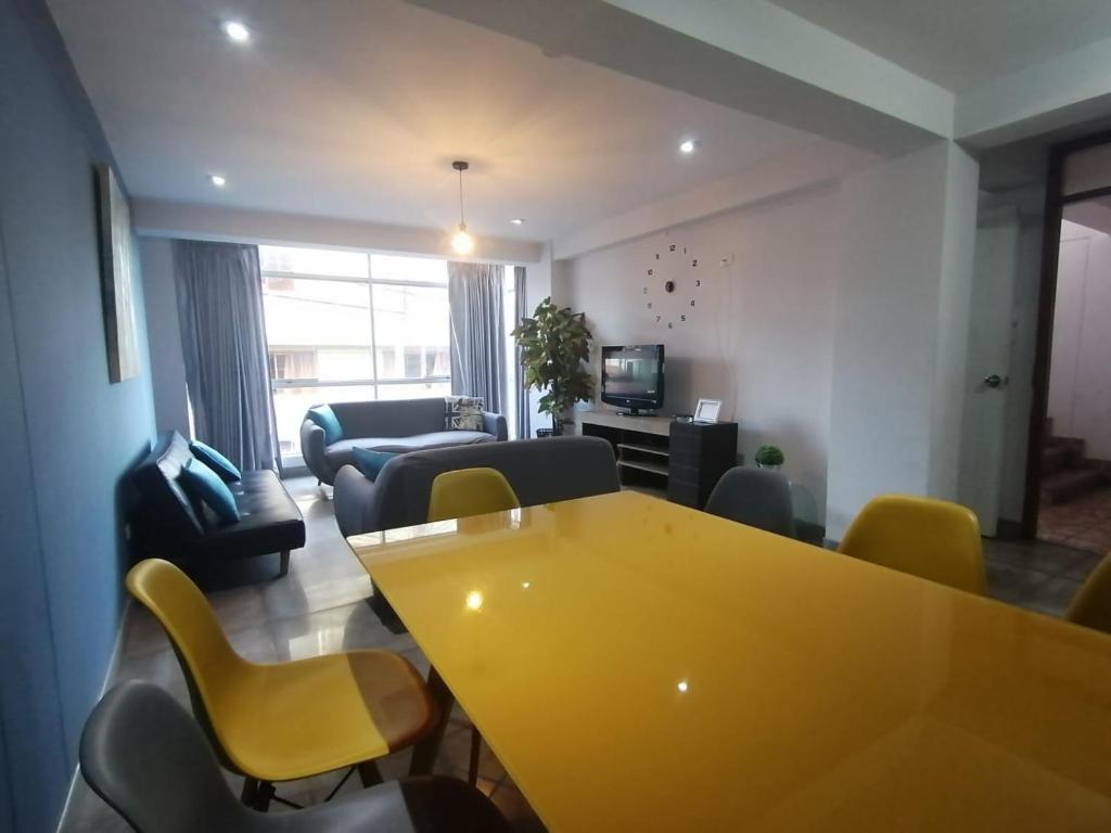 sala de estar con mesa amarilla y sillas en Cusco Cozy Apartment, en Cusco