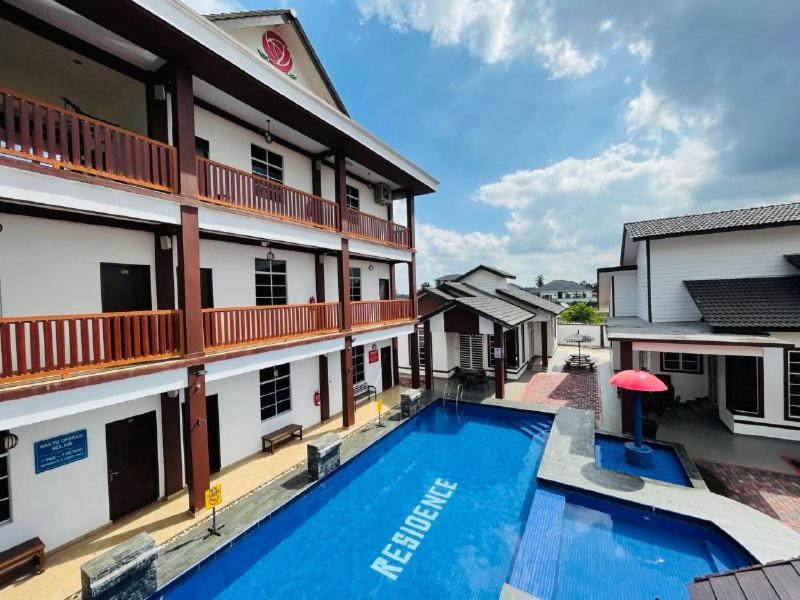 a hotel with a swimming pool in front of a building at Dz Residence Tunjong in Kota Bharu
