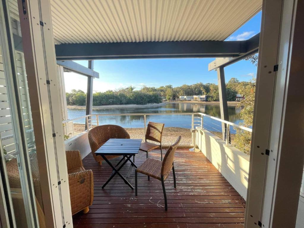 a porch with a table and chairs and a view of the water at Couran Cove Resort Private Apartments, South Stradbroke Island, Gold Coast in South Stradbroke